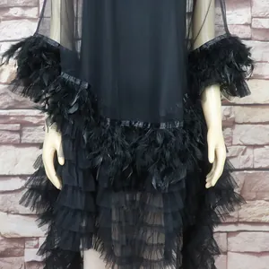 Close-up detail of black mesh African fashion dress featuring soft feathered trims
