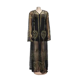 Detail des schwarzen Mesh-Maxikleids im afrikanischen Stil mit goldenen Herzmustern.