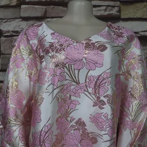 Nahaufnahme des rosa-goldenen Blumenmusters auf dem afrikanischen BUBU-Kleid mit Fledermausärmeln