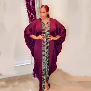 Detail of elegant African plus size maxi dress in burgundy with gold Greek key pattern
