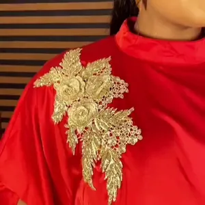 Close-up of golden floral rhinestone applique on red African style rayon dress