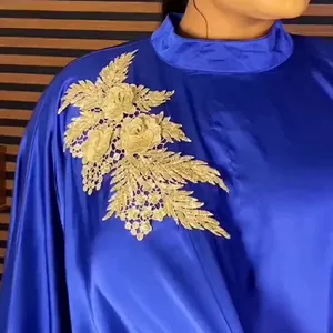 Close-up showing the intricate golden floral lace applique on a blue African ethnic rayon dress