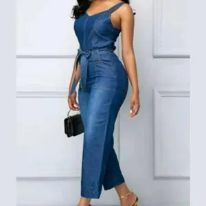 Detailansicht eines modischen blauen Jumpsuits aus gewaschenem Denim mit Gürtel und Trägern