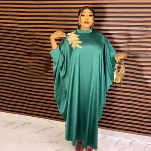 Detail view of African ethnic green rayon caftan dress featuring gold floral applique