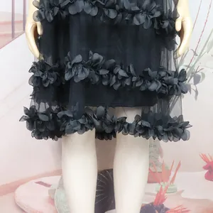 Detailed macro view of black mesh dress featuring 3D floral petal layers for dance