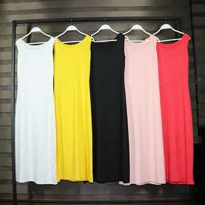 Detailed view of five solid-colored sleeveless maxi dresses on a garment rack