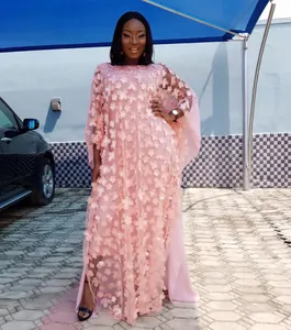 Vue détaillée d'une robe maxi africaine rose ornée de broderies florales en 3D.