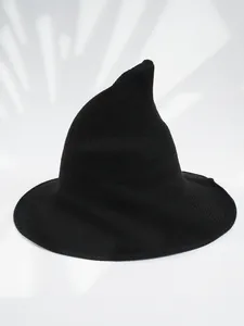 Detail view of a minimalist black knitted pointed witch hat for Halloween costume parties