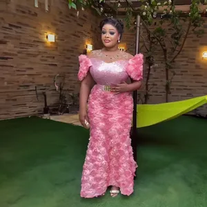 Detailansicht eines rosa afrikanischen Abendkleids mit 3D-Blumenstickerei und Pailletten.
