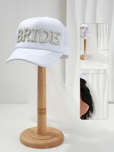 Dettaglio ravvicinato cappello sposa bianco con lettere BRIDE in perle e velo nuziale