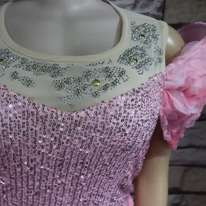 Nahaufnahme eines rosa Pailletten-Abendkleids mit Tüll-Ausschnitt und Silberperlen