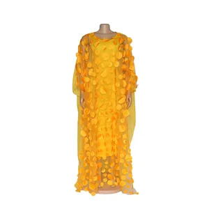 Detailed view of yellow African long dress with 3D floral applique on mannequin