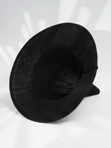 Detailed view of a minimalist black knitted pointed witch hat for Halloween costume parties