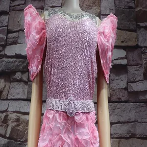 Detailaufnahme eines rosa Pailletten-Abendkleides mit 3D-Blumenärmeln und Gürtel