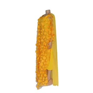 Side profile detail of a yellow African long dress with 3D floral applique elements