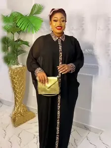 Elegant black plus-size African robe dress with leopard print accents and gold clutch bag