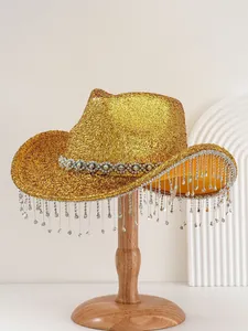 Detailed view of shiny gold glitter cowboy hat with rhinestone fringe on wooden stand