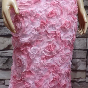 Detaillierte Nahaufnahme der pinken 3D-Blumenstickerei auf dem Stoff eines Abendkleids