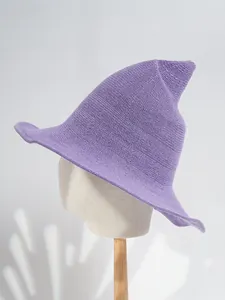 Detailed view of a purple knitted witch hat with a whimsical pointed top on a mannequin