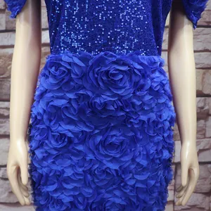 Makroaufnahme der königsblauen 3D-Blumenstickerei und funkelnden Pailletten am Abendkleid.