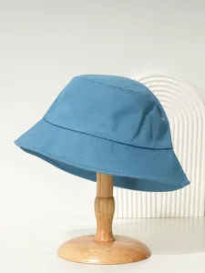 Seitenansicht eines blauen Baumwoll-Fischerhuts auf einem Holzständer