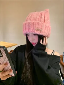 Close-up of a pink cat ear knitted beanie worn by an Asian model in a cozy cafe setting