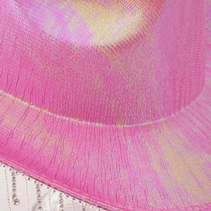 Macro del tessuto rosa iridescente di un cappello da cowboy con frange di strass.
