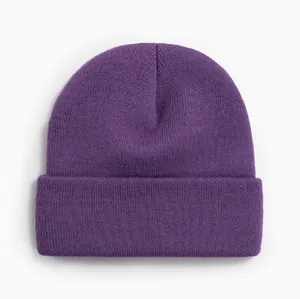 Gros plan d'un bonnet en tricot violet uni montrant la texture côtelée et le revers