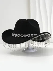 Detailed shot of a black cowboy hat featuring crystal heart band and rhinestone tassels