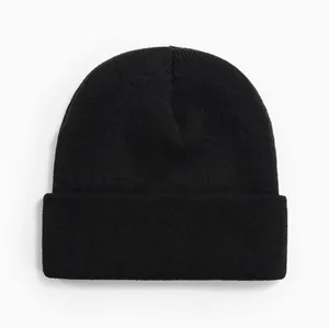 Gros plan détaillé d'un bonnet en maille noir uni montrant la texture fine des côtes.