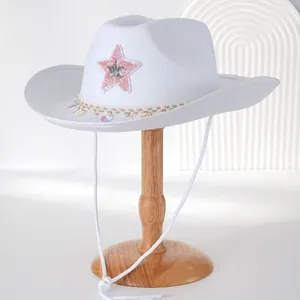 Detailansicht eines weißen Cowboyhuts mit einem rosa Paillettenstern und Borte.