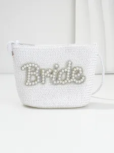 Detailed view of the white woven bride bag with pearl and rhinestone letter decoration