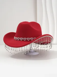 Detailed view of a bright red cowboy hat with heart rhinestones and crystal tassels