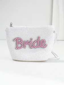 Close-up of white woven bride pouch with pink pearl and rhinestone lettering.