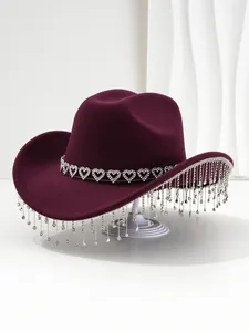 Detail view of burgundy cowboy hat featuring heart rhinestone band and sparkling tassels