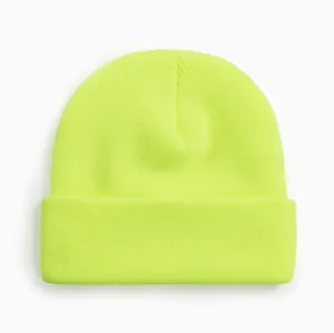 Gros plan d'un bonnet en tricot jaune néon vibrant avec un bord replié classique.