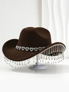 Detail showing a brown cowboy hat with heart-shaped band and sparkling crystal tassels.