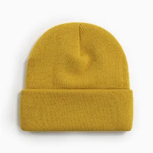 Gros plan détaillé d'un bonnet d'hiver jaune moutarde classique en maille acrylique.