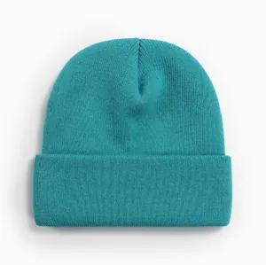 Gros plan d'un bonnet en tricot bleu sarcelle montrant sa texture en acrylique.
