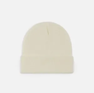 Vue détaillée d'un bonnet en tricot blanc cassé doux avec un design de revers classique
