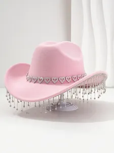 Detailed view of pink cowboy hat featuring rhinestone heart band and crystal fringe
