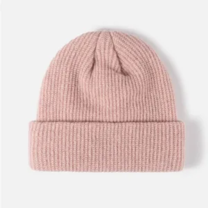 Vue détaillée d'un bonnet en tricot rose tendre pour l'hiver avec texture côtelée