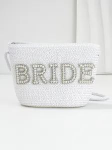 Close-up of white woven straw bag featuring pearl and rhinestone BRIDE patch detail