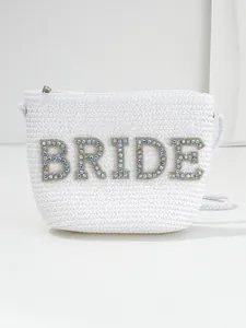Close-up detail of white straw bridal handbag with sparkling rhinestone BRIDE letters