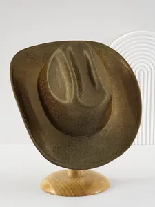 Dettaglio di un cappello da cowboy dorato lucido con finitura metallica su supporto