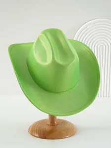 Primo piano di un cappello da cowboy verde glitterato su un supporto di legno per spettacoli.