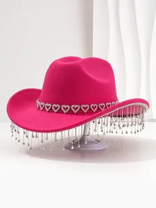 Detailed view of a stylish pink cowboy hat with heart rhinestones and fringe tassels.