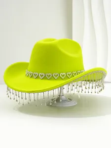 Detail of lime green cowboy hat featuring heart rhinestones and crystal tassels