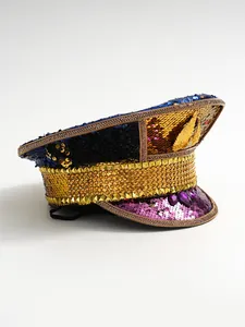 Close-up of a Y2K stage hat with colorful sequins, gold wing emblem, and rhinestone studs.