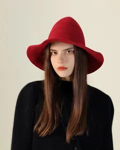 Elegant model wearing a red knitted pointed witch hat, a stylish Halloween accessory.